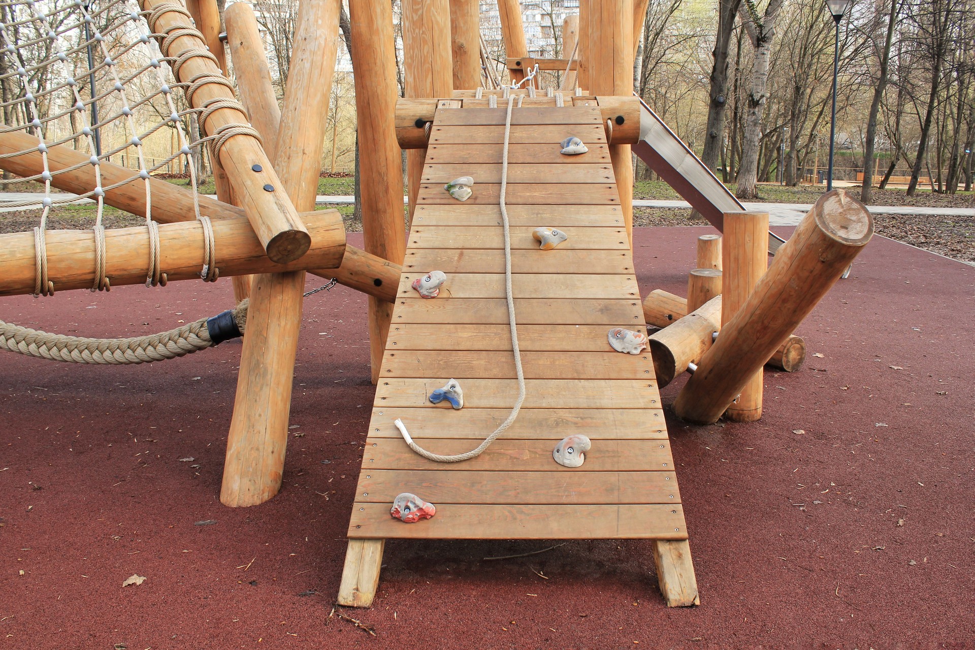 Climbing and ladder in outdoor modern children wooden playground in a public park of city.